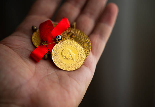 Human hand holding Turkish Gold coin in hand stock photo