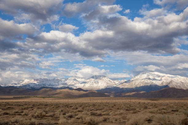 istock sunny morning with snowy mountain peaks and clouds 1328604101