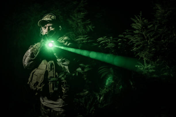 operador de operaciones de especificaciones militares nocturnas en acción con láser verde dirigido cerca de la cámara - black ops fotografías e imágenes de stock