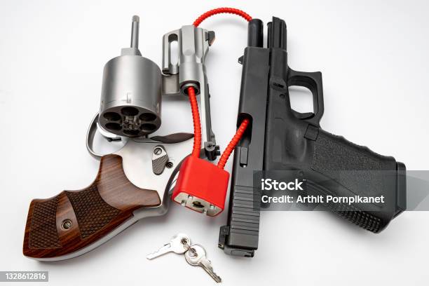 Revolver And Automatic Gun With Cable Lock Locked Disarmed And Secured Weapons Gun Safety In Home Concept Stock Photo - Download Image Now