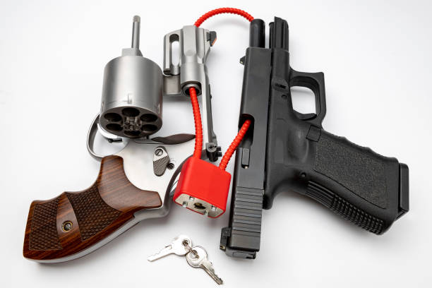 revólver e arma automática com trava de cabo, armas desarmadas e fixas, segurança de armas no conceito de casa - gun control - fotografias e filmes do acervo