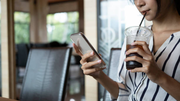 istock Young female drinking coffee and using smart phone. 1328612876