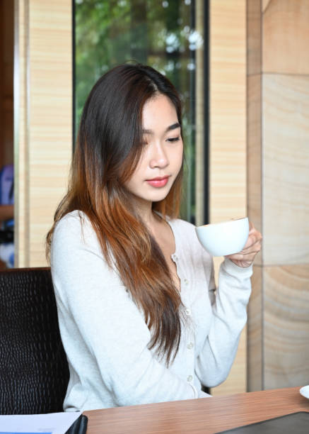 istock Young woman drinking coffee in modern office. 1328612943
