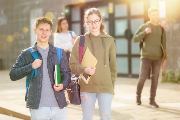 istock Two positive teens walk along street 1328618022
