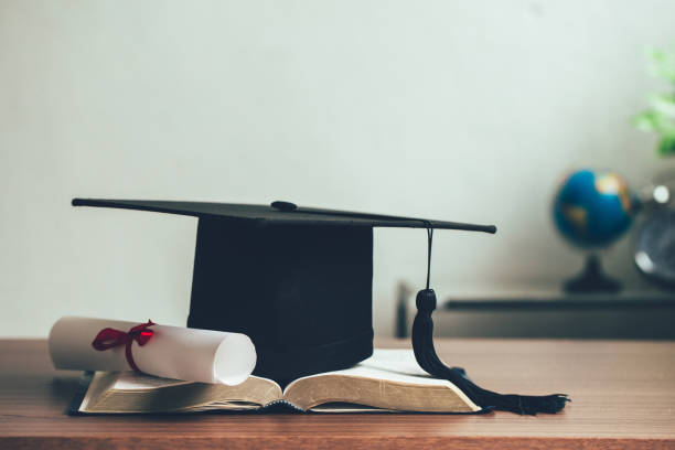 istock A mortarboard and graduation scroll on open books on the desk.education learning concept 1328618966