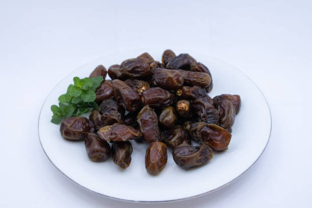 istock pile of dates with green leaf garnish 1328620327