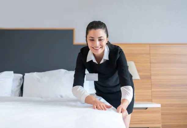 Photo of Housekeeper Making A Bed In Hotel Room