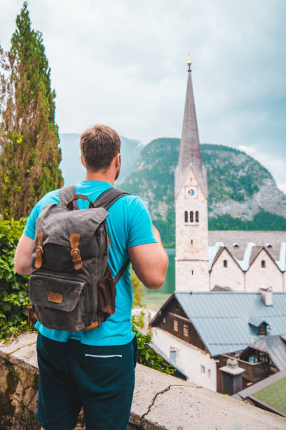 istock strong young man looking at hallstatt church 1328621156