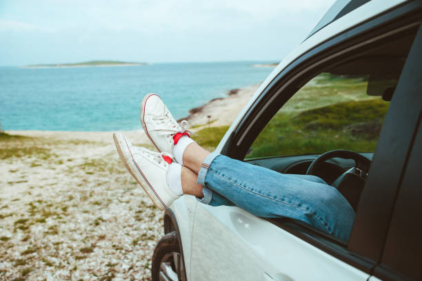 istock men legs stick out from car parked at sea beach 1328621195