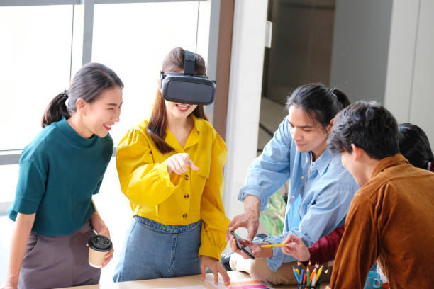 istock VR mobile phone application test, Asian woman with virtual reality glasses headset in VR experience, Asia business team developers for reality simulator smartphone app test at creative office, ui 1328621294