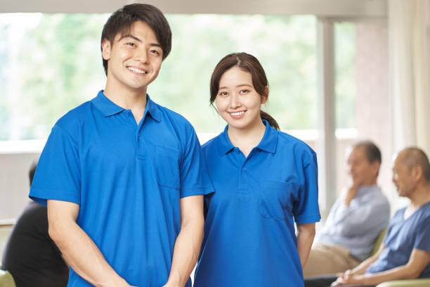 male and female caregivers working in long-term care facilities - polo shirt two people men working imagens e fotografias de stock