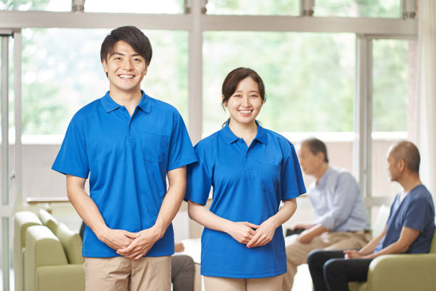 male and female caregivers working in long-term care facilities - polo shirt two people men working imagens e fotografias de stock