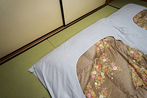 Japanese style mattresses placed on a tatami mat in a Japanese-style bedroom (Ryokan).