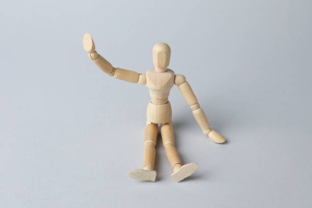 istock Wooden human model on grey background. Mini mannequin 1328628410
