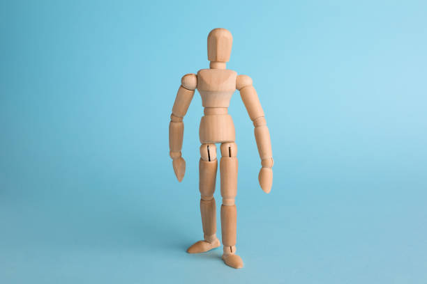 istock Wooden human model on light blue background. Mini mannequin 1328628424