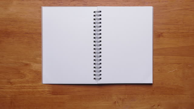 4k : Stop motion of hand open notebook with blank page on wooden background