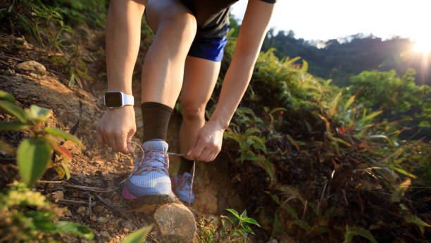 istock Woman runner tying shoelace on mountain trail 1328628802