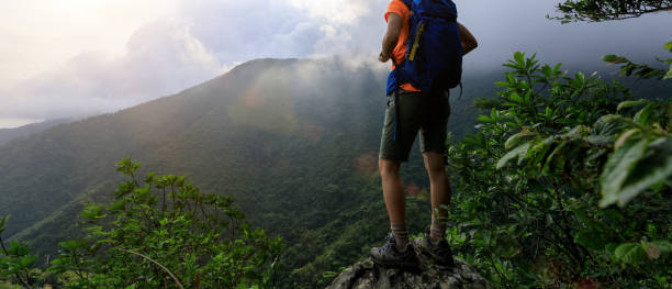 istock Successful hiker enjoy the view on mountain top cliff edge 1328630008