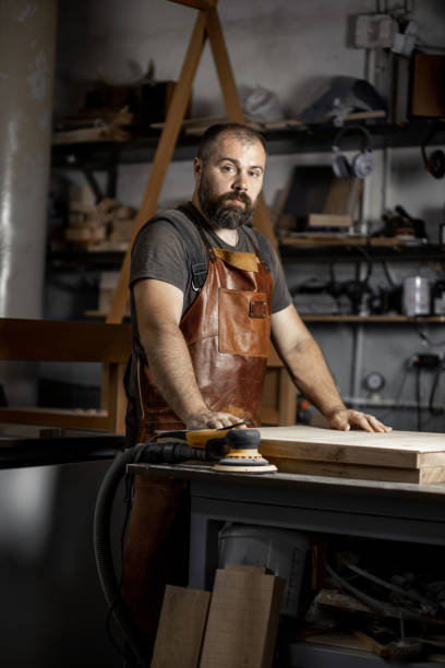 istock Portrait of a brutal master carpenter in an apron in workshop 1328631016