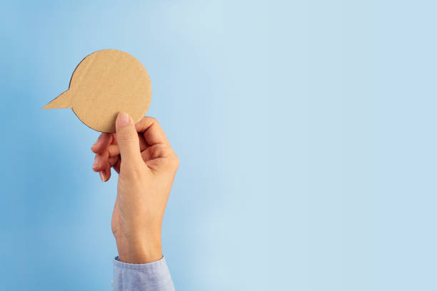 istock Female hand holding blank paper speech bubble 1328631164