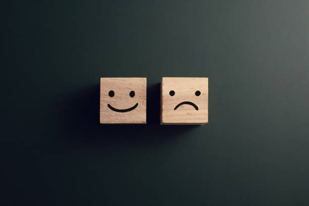 istock Angry And Smiley Face Wooden Blocks On Dark Background 1328631168