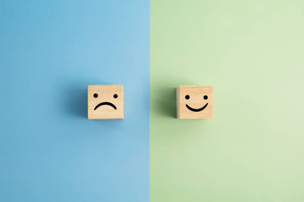 Angry And Smiley Face Wooden Blocks On Colored Background stock photo