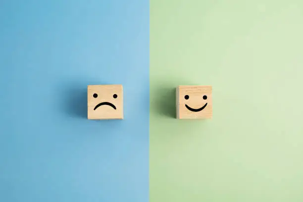 Photo of Angry And Smiley Face Wooden Blocks On Colored Background
