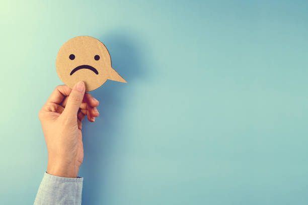 istock Hand holding A Sad Face Paper Speech Bubble 1328631203