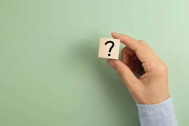 istock Cropped Hand Holding A Question Mark Sign Wooden Blocks Against Colored Background 1328631231