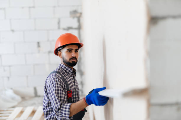 istock Decorative plaster applied on the surface by a steel trowel. White cement based decorative top coat plaster resistant on outside whether conditions. Gypsum Workers . 1328632311