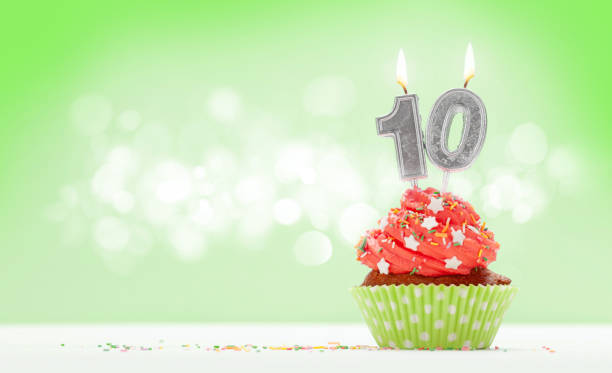 Birthday cupcake with number ten Birthday cupcake with number ten burning candle over green background with copy space for your greetings birthday cake green stock pictures, royalty-free photos & images