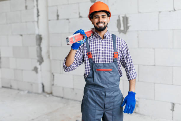 istock Mason checking horizontal level of house wall layer being made from aerated autoclaved blocks 1328635011