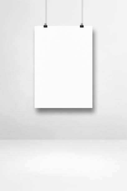 istock White poster hanging on a clean wall with clips 1328635736