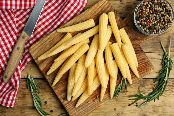 istock Fresh baby corn cobs and spices on wooden table, flat lay 1328638447