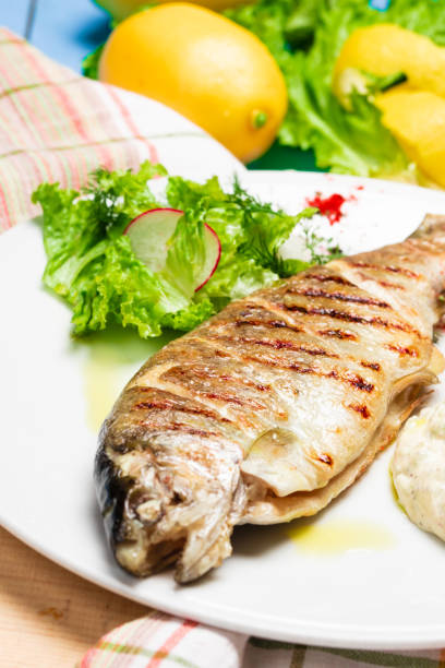 istock Grilled seabass with lemon and fresh vegetables. Rustic Served Dish 1328641479