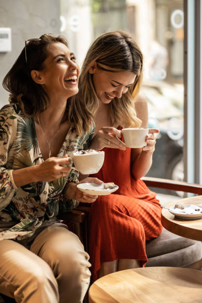 Coffee Time Beautiful happy women talking and laughing while drinking coffee together in coffee shop. coffee drink stock pictures, royalty-free photos & images