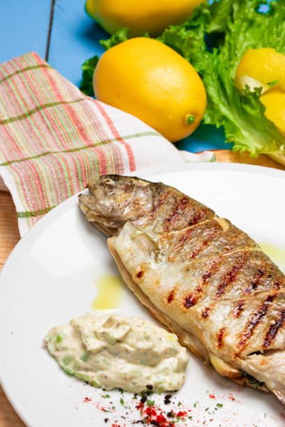 istock Grilled seabass with lemon and fresh vegetables. Rustic Served Dish 1328642101
