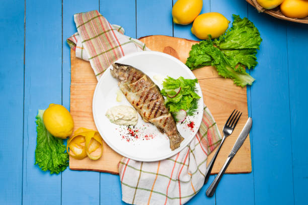 istock Grilled seabass with lemon and fresh vegetables. Rustic Served Dish 1328643213