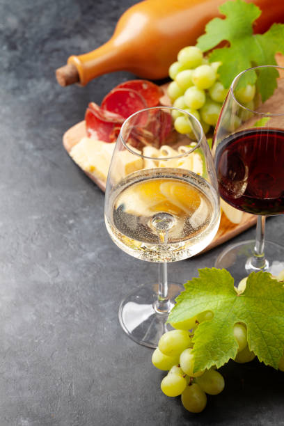 istock White and red wine glasses, grape and appetizer board 1328647001