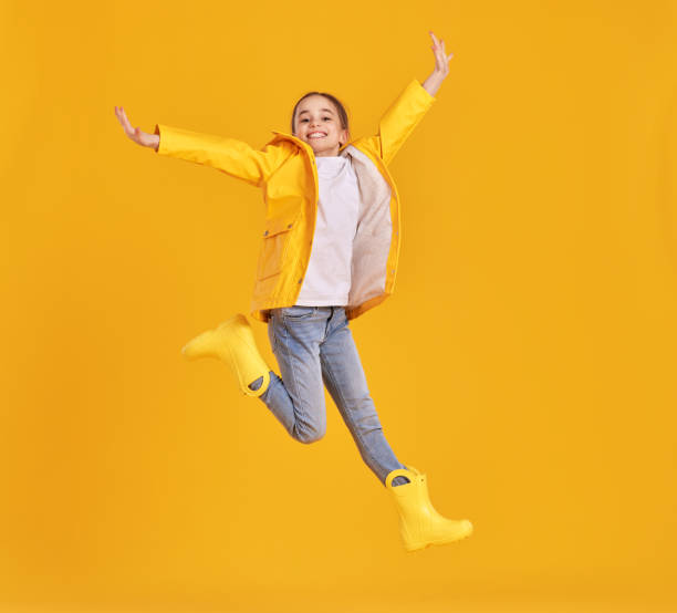 istock Jumping kid in raincoat and gumboots 1328648904