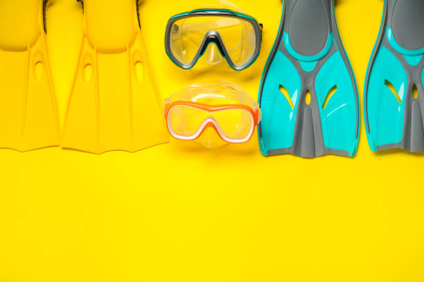 istock Different flippers and masks on yellow background, flat lay. Space for text 1328648991