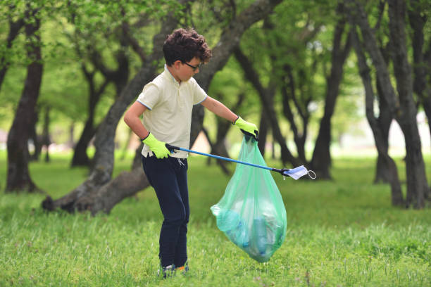 Recycle waste litter rubbish garbage trash junk clean training. Nature cleaning, volunteer ecology green concept. Young men and boys pick up spring forest at sunset. Environment plastic pollution stock photo