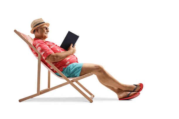 зрелый мужчина-турист читает книгу и сидит в кресле-беке - bech стоковые фото и изображения