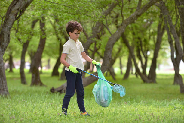 istock Recycle waste litter rubbish garbage trash junk clean training. Nature cleaning, volunteer ecology green concept. Young men and boys pick up spring forest at sunset. Environment plastic pollution 1328649730