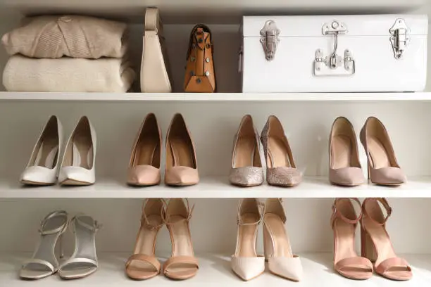 Photo of Stylish women's shoes, clothes and bags on shelving unit