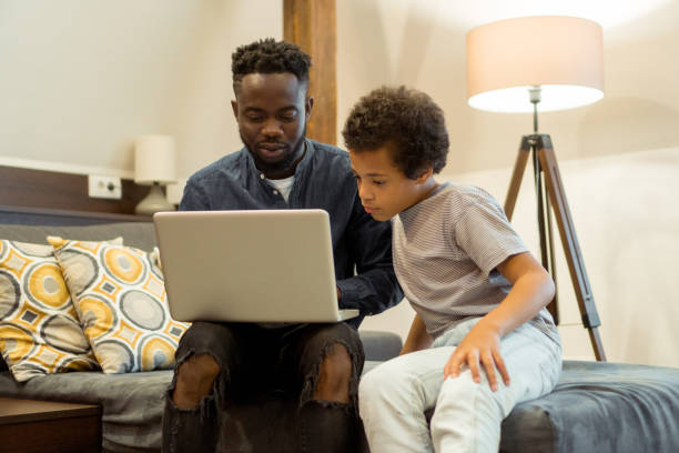 istock Father and son using laptop at home 1328651109