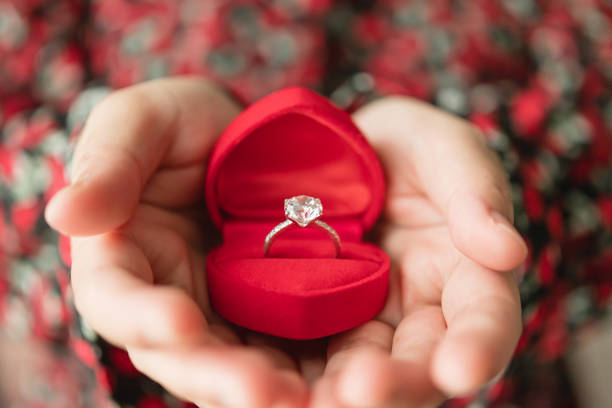 istock hands holding diamond ring in jewelry box 1328652392