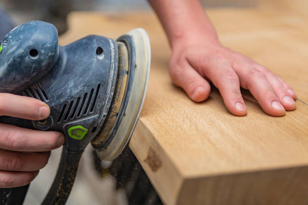 istock A carpenter works in a workshop. Joiner's grinders, furniture manufacturing. A carpenter is grinding a wooden part with an electric sander. place to insert text 1328652407
