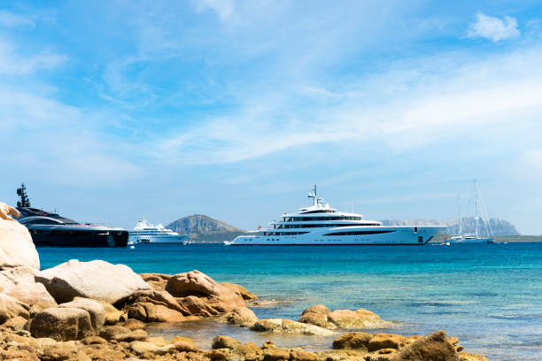 wspaniały widok na niektóre luksusowe jachty pływające na turkusowej wodzie w słoneczny dzień. cala di volpe bay, costa smeralda, sardynia, włochy - bay large nautical vessel blue zdjęcia i obrazy z banku zdjęć