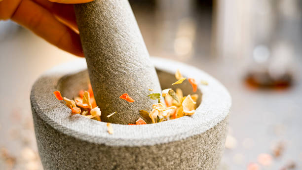 Close-up of dried vegetables being crushed in a stone mortar and pestle.